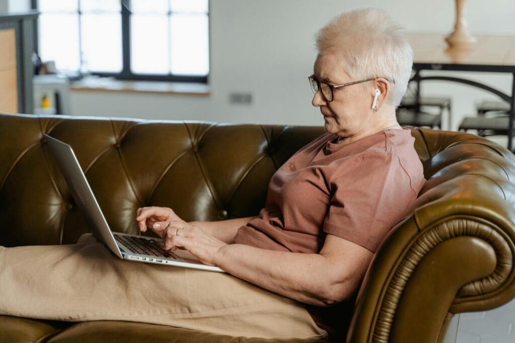 woman in brown shirt using a laptop
